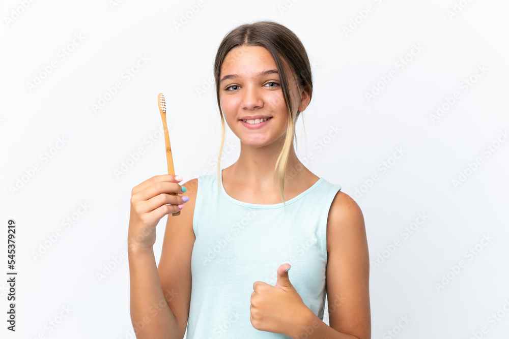Little caucasian girl holding a toothbrush isolated on white background with thumbs up because something good has happened Little caucasian girl holding a toothbrush isolated on white background with thumbs up because something good has happened