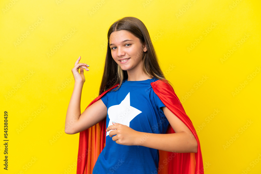 Little caucasian superhero girl isolated on yellow background making guitar gesture Little caucasian superhero girl isolated on yellow background making guitar gesture