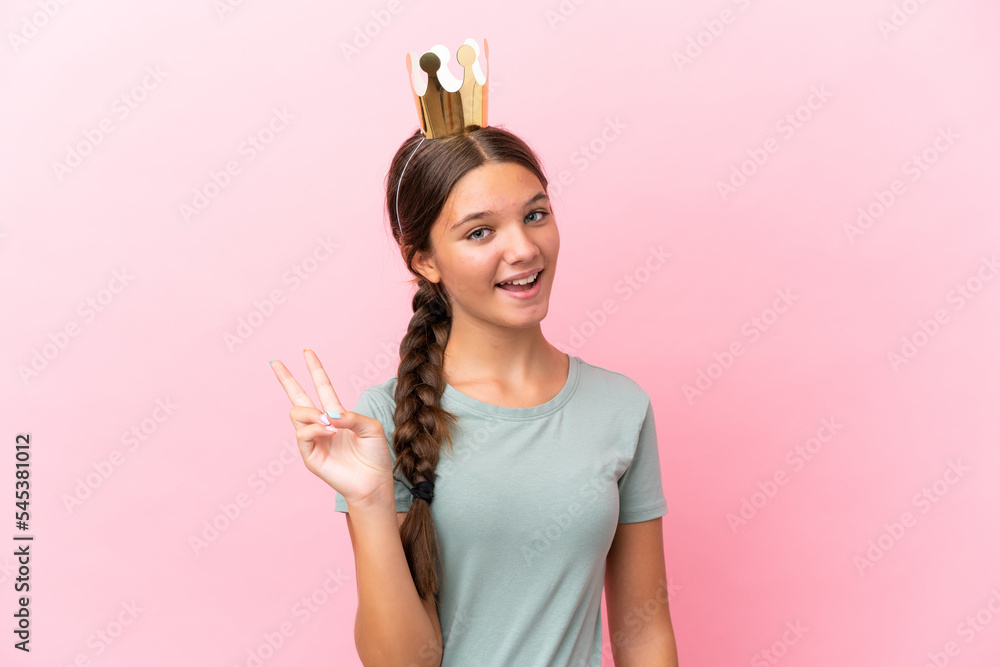 Little caucasian princess girl isolated on pink background smiling and showing victory sign Little caucasian princess girl isolated on pink background smiling and showing victory sign