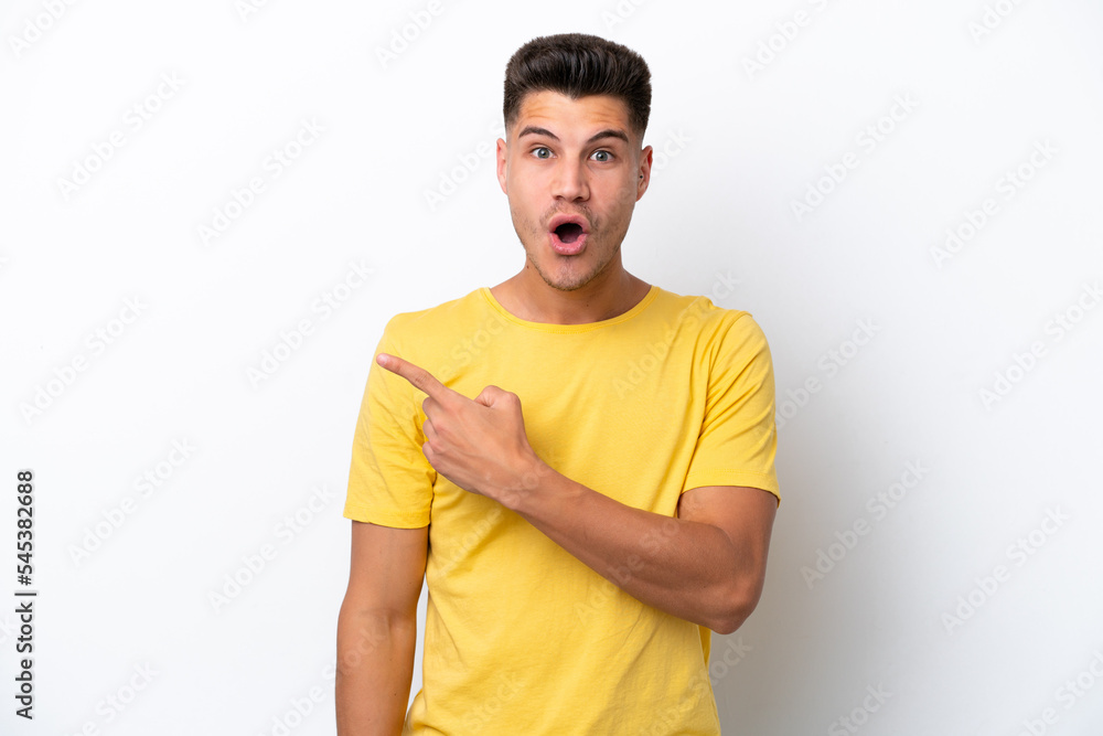 Young caucasian man isolated on white background surprised and pointing side Young caucasian man isolated on white background surprised and pointing side