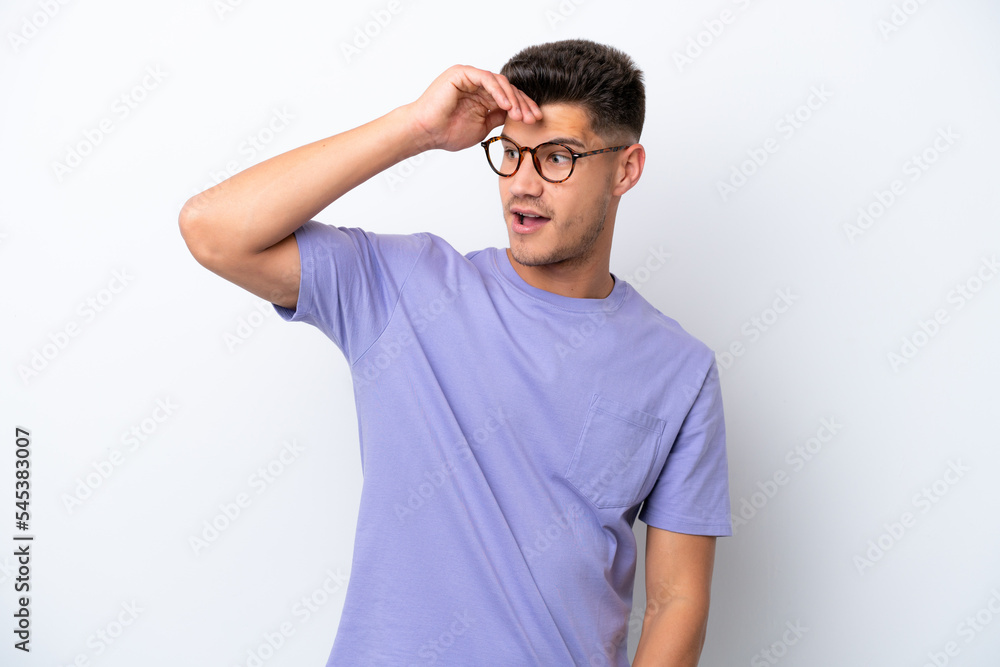 Young caucasian man isolated on white background doing surprise gesture while looking to the side Young caucasian man isolated on white background doing surprise gesture while looking to the side