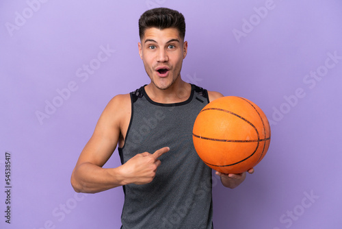 young caucasian woman basketball player man isolated on purple background with surprise facial expression