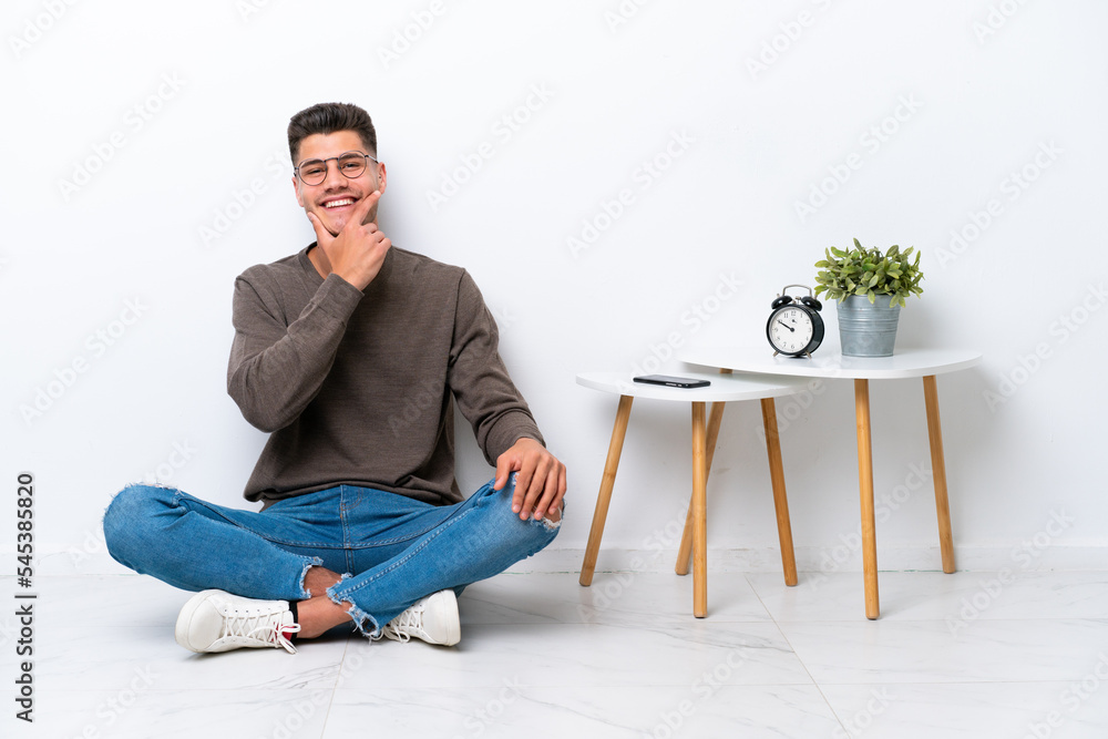 Young caucasian man sitting in his home isolated on white background happy and smiling Young caucasian man sitting in his home isolated on white background happy and smiling