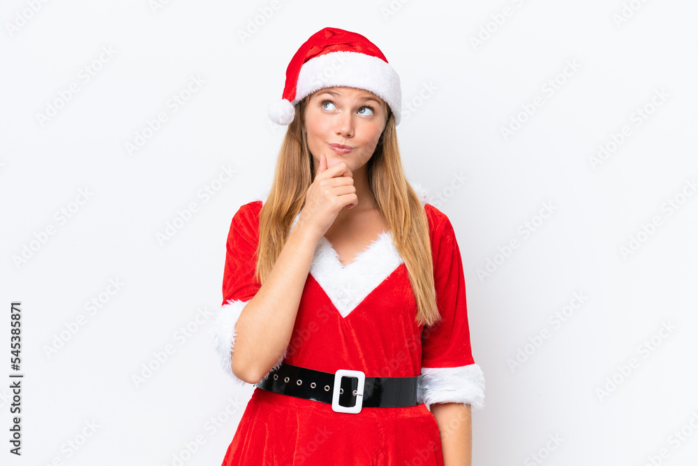 Young caucasian woman dressed as mama noel isolated on white background and looking up Young caucasian woman dressed as mama noel isolated on white background and looking up