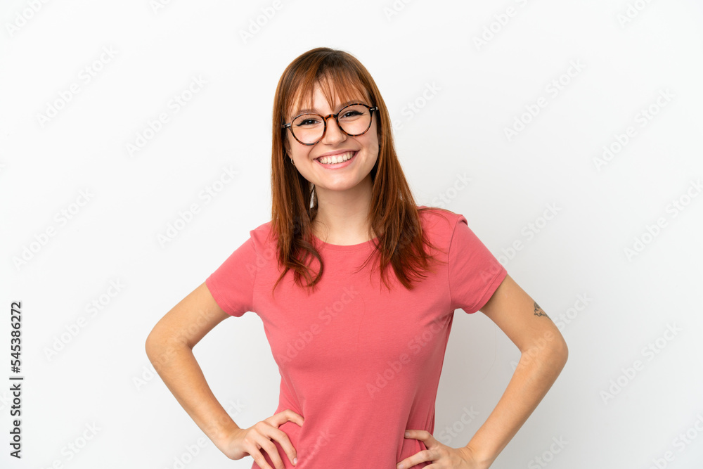 Redhead girl isolated on white background posing with arms at hip and smiling Redhead girl isolated on white background posing with arms at hip and smiling