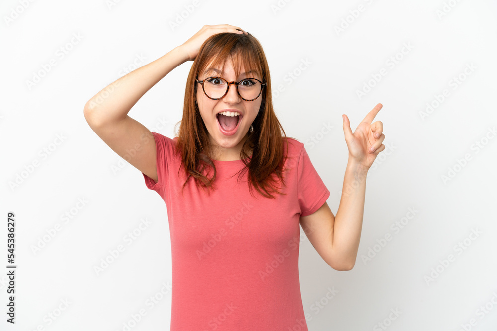 Redhead girl isolated on white background surprised and pointing finger to the side Redhead girl isolated on white background surprised and pointing finger to the side