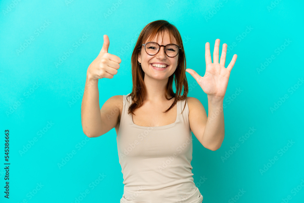 Redhead girl isolated on blue background counting six with fingers Redhead girl isolated on blue background counting six with fingers