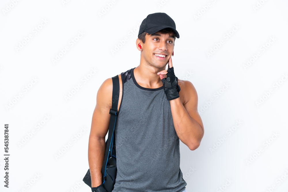 Young sport caucasian man with sport bag isolated on white background thinking an idea while looking up Young sport caucasian man with sport bag isolated on white background thinking an idea while looking up