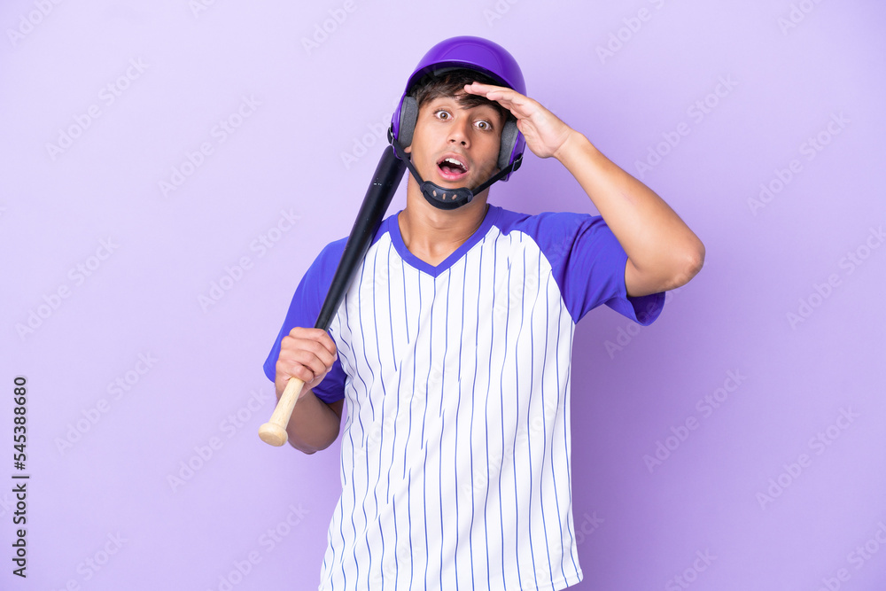 Baseball caucasian man player with helmet and bat isolated on blue background doing surprise gesture while looking to the side Baseball caucasian man player with helmet and bat isolated on blue background doing surprise gesture while looking to the side