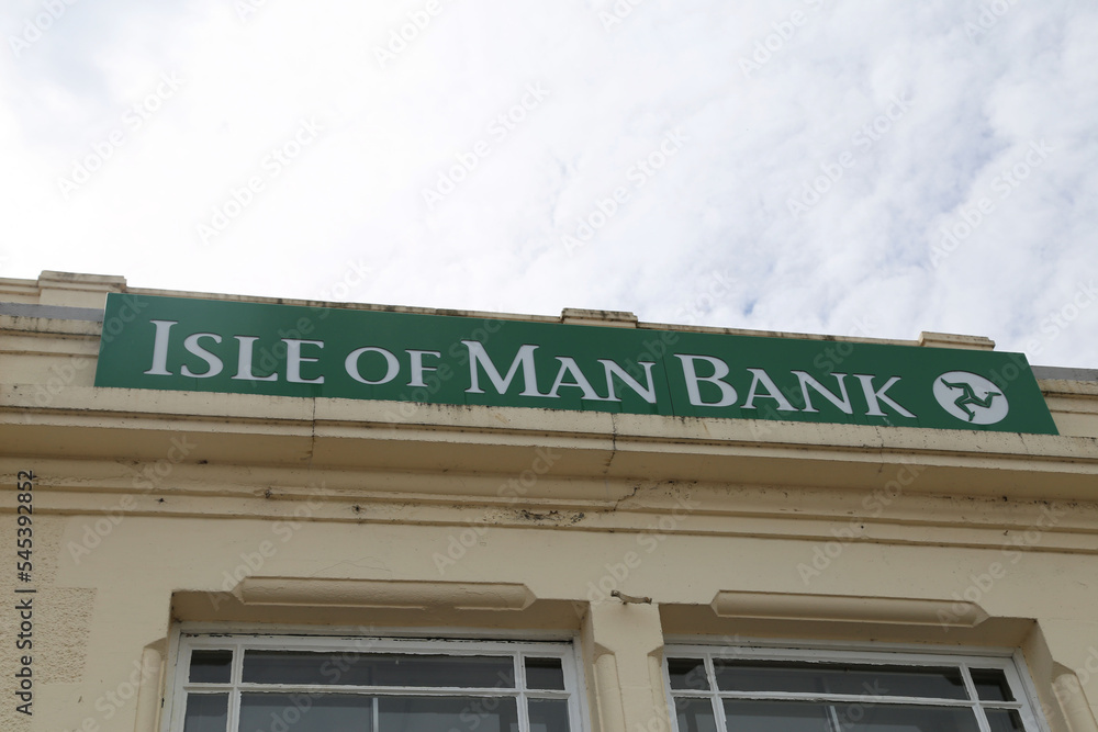 Foto de The green sign with triskelion for the Isle of Man Bank in the main street of Ramsey on