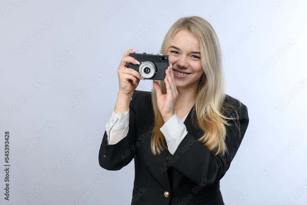 Young beautiful blonde woman holding old film camera on white background. Young beautiful blonde woman holding old film camera on white background.