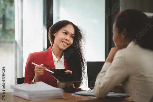 Two American women are working together in the office of a startup company. They are having a brainstorming and planning meeting in a joint department, women leading the way. Concept of women's work.