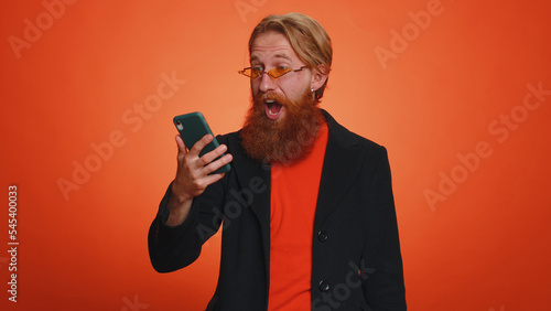 Happy excited joyful man in casual jacket use mobile cell phone typing browsing shouting say wow yes found out great big win, good news, lottery goal achievemen, celebrating success, winning © Andrii Iemelianenko