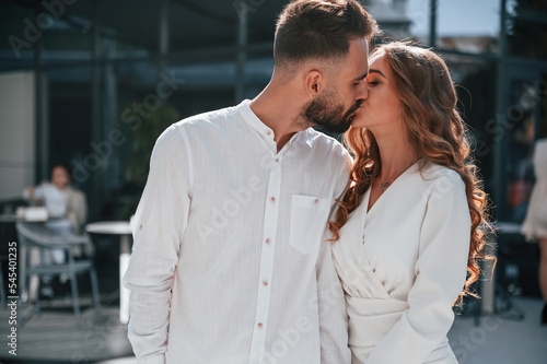 Kissing each other. Beautiful young couple together outdoors on the street © standret