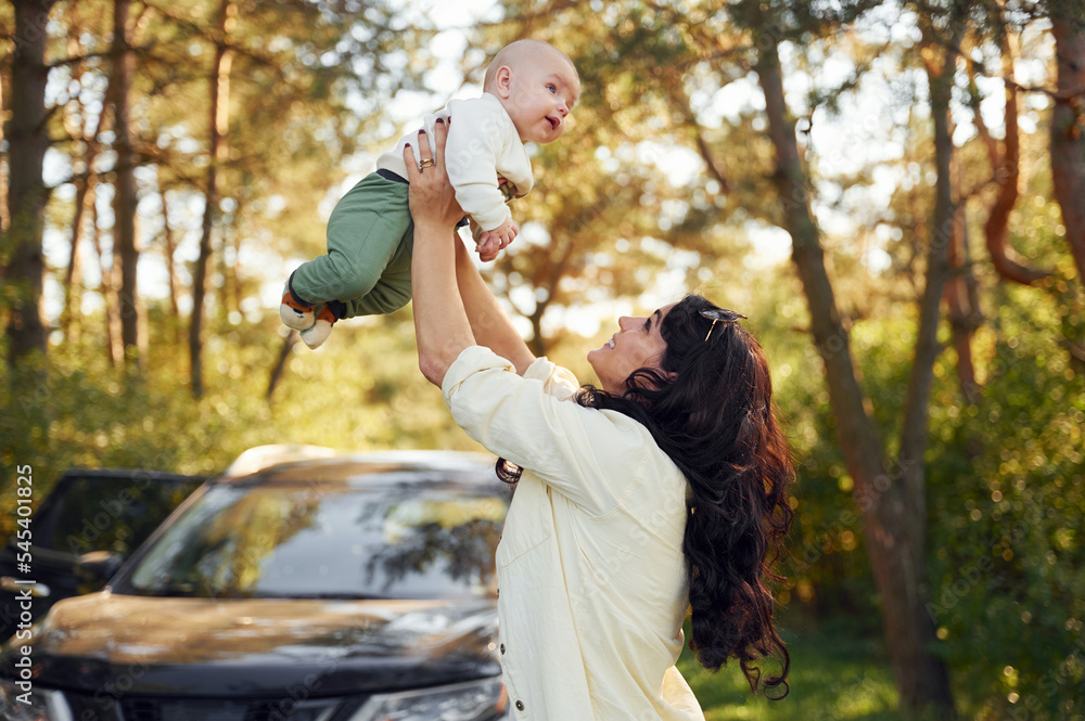 Fototapeta premium Beautiful mother with her little son is outdoors in the forest