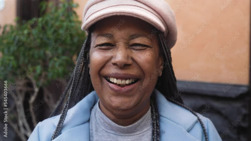Happy senior African woman having fun looking in front of a camera in city Happy senior African woman having fun looking in front of a camera in city