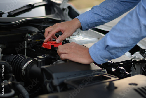 man checking the engine of a car