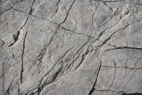 Light grey rock texture background with cracked surface 