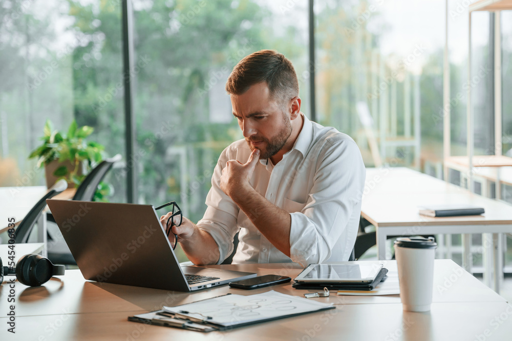 Thoughtful look. Man in formal clothes is working in the modern office Thoughtful look. Man in formal clothes is working in the modern office