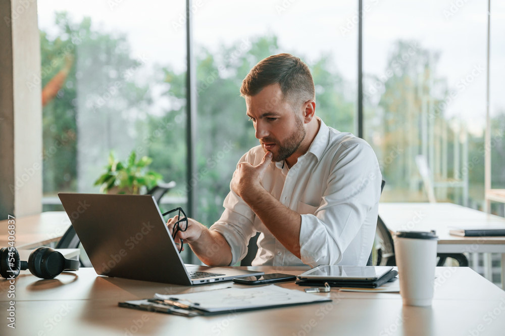 Thoughtful look. Man in formal clothes is working in the modern office Thoughtful look. Man in formal clothes is working in the modern office