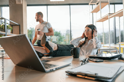Sitting with legs on the table. Man and woman are working in the modern office together © standret