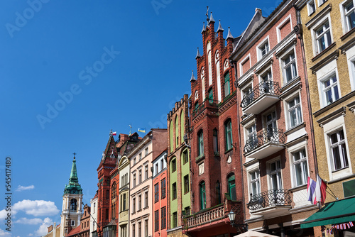 The belfry of a church and facades of historic tenement houses in Torun © GKor