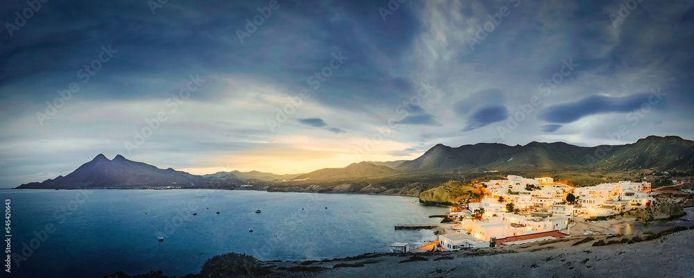 relaxing panoramic view of the sunset over the sea and the quiet village of la isleta del moro in the natural park of cat cape