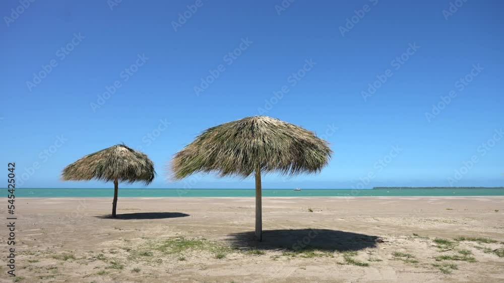 Amazing seascape of an empty tropical beach with thatched parasols. Calm relaxing atmosphere Amazing seascape of an empty tropical beach with thatched parasols. Calm relaxing atmosphere