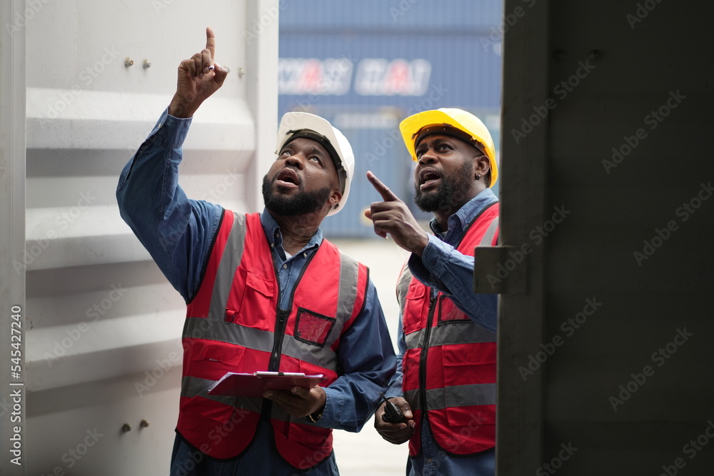 Dock worker man in safety vest work in container port terminal. male Industrial Engineer in Hard Hat, High-Visibility Vest Working. Inspector or Safety Supervisor in Container Terminal. shipping yard. Dock worker man in safety vest work in container port terminal. male Industrial Engineer in Hard Hat, High-Visibility Vest Working. Inspector or Safety Supervisor in Container Terminal. shipping yard.