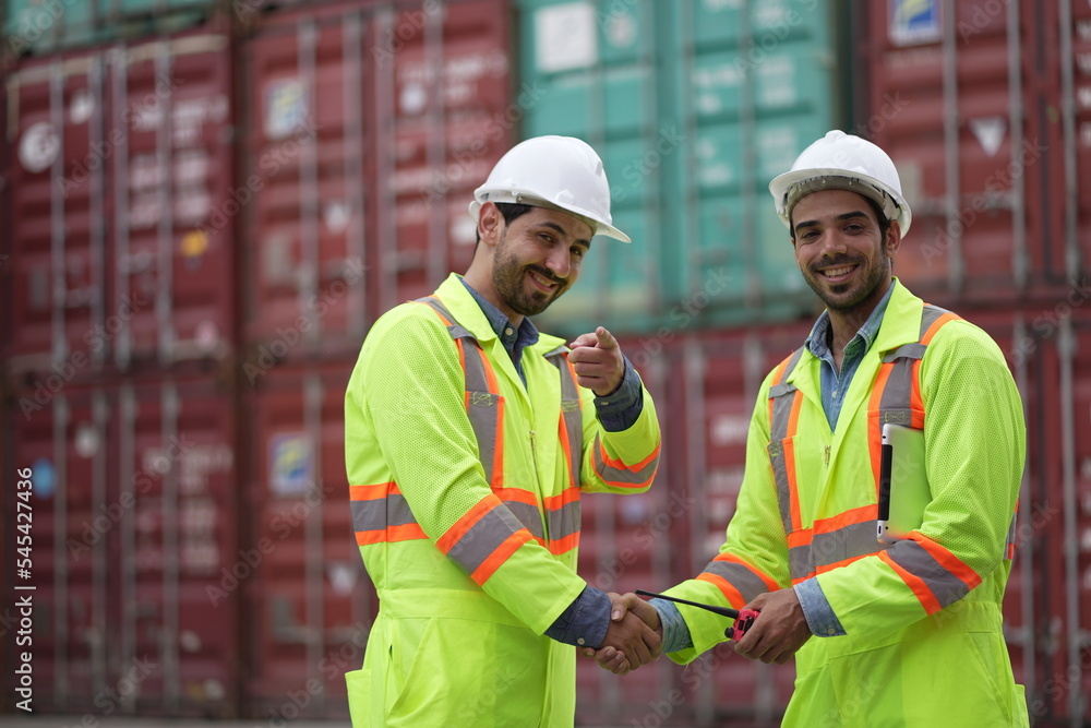 Dock worker man in safety vest work in container port terminal. male Industrial Engineer in Hard Hat, High-Visibility Vest Working. Inspector or Safety Supervisor in Container Terminal. shipping yard. Dock worker man in safety vest work in container port terminal. male Industrial Engineer in Hard Hat, High-Visibility Vest Working. Inspector or Safety Supervisor in Container Terminal. shipping yard.