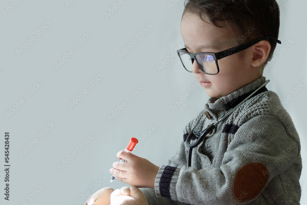a little boy with glasses and a cell in his hand while he looks at something on the screen that is connected to him a little boy with glasses and a cell in his hand while he looks at something on the screen that is connected to him