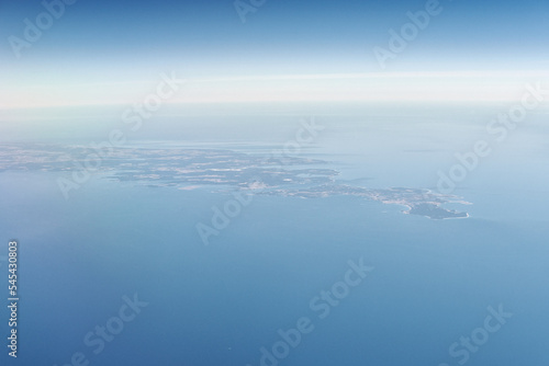 Aerial view from airplane window to Gotland island in Baltic sea, beautiful largest island in Sweden. Beautiful hazed sky aerial view to blue baltic sea, aerial seascape background photo