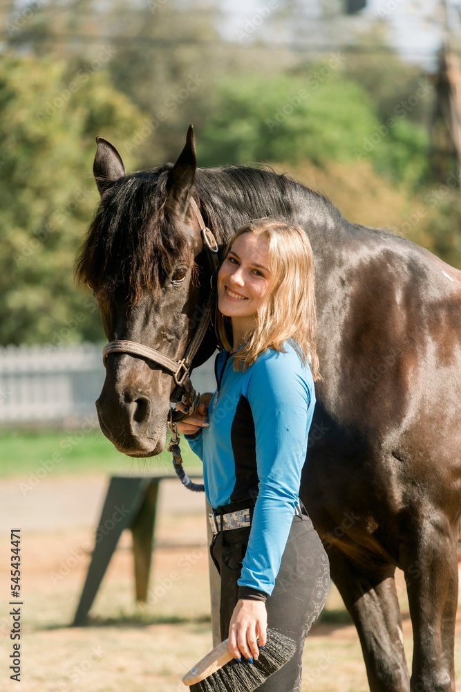 Obraz premium Vertical shot of a young female with a horse