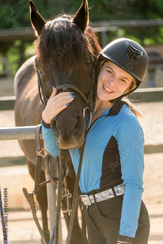 Vertical shot of a young female with a horse at the farm