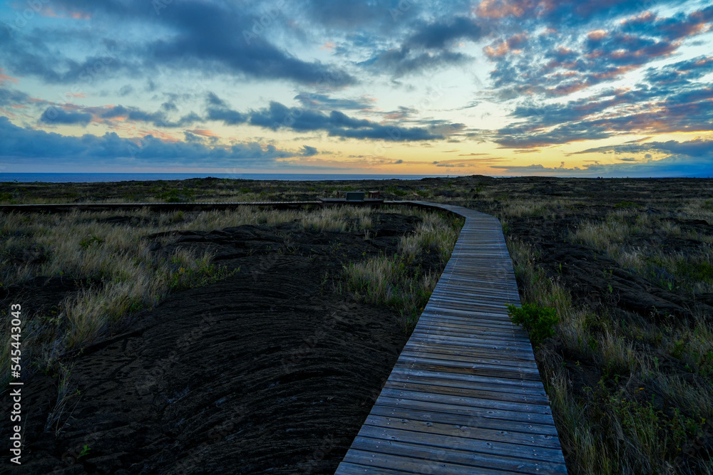 Sunset on a boardwalk over the lava field of the Pu'u Loa Petroglyphs trail along the Chain of Craters Road in the Hawaiian Volcanoes National Park on the Big Island of Hawaii in the Pacific Ocean