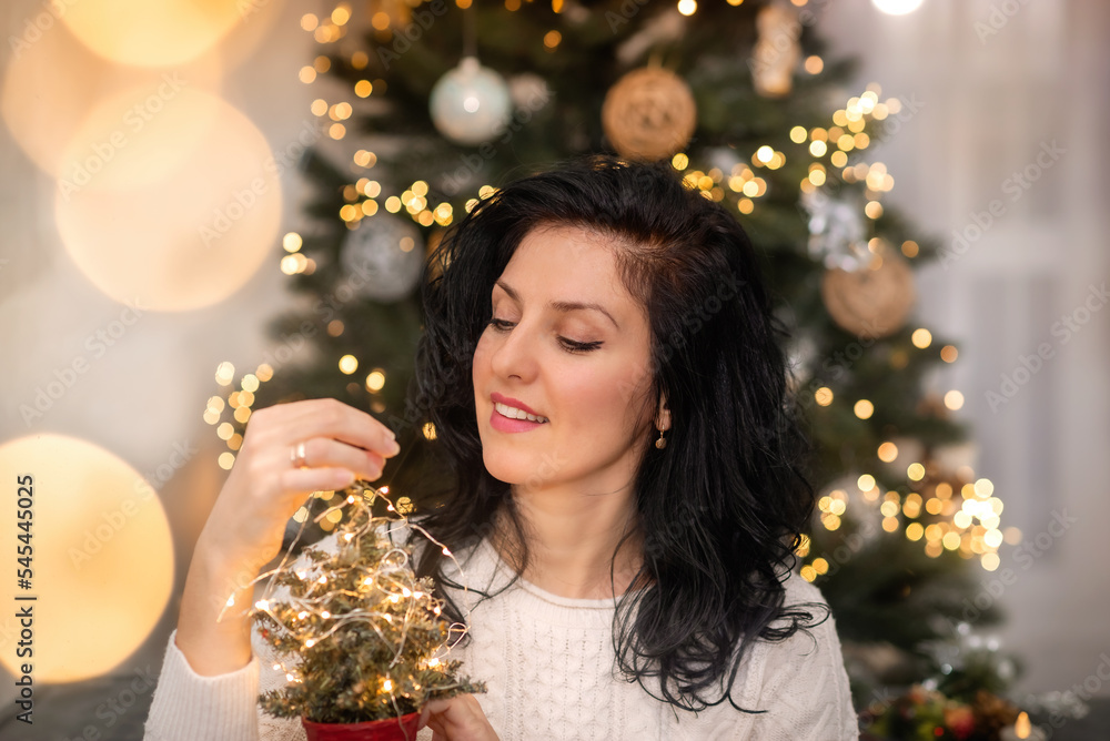 woman is decorating a Christmas tree woman is decorating a Christmas tree