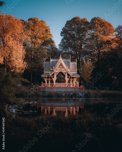 Vertical shot of a beautiful neo-gothic mansion at the pond photo