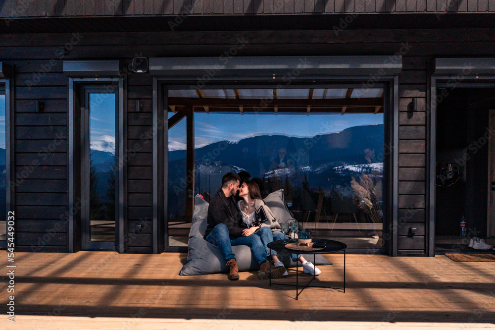 Fototapeta premium A couple of people near a mountain house.