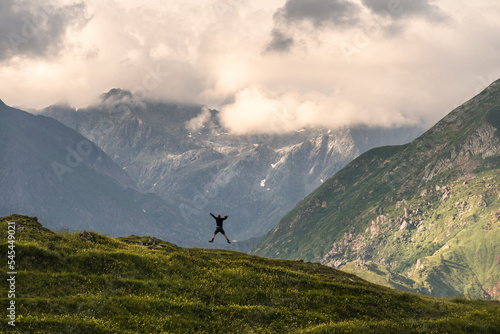 A person walking at sunset on top of the ridge of a mountain in the Orobie Alps, Northern Italy