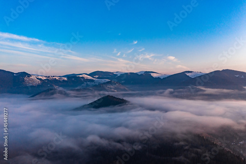 Carpathian peaks in the morning in the clouds, top view, drone footage.