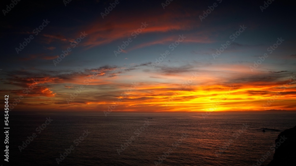 Bright glowing sunset sky over a calm sea in Algarve, Portugal