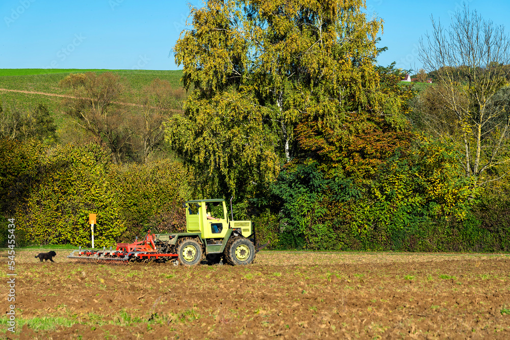 Fotografie Traktor mit Federzinkenegge