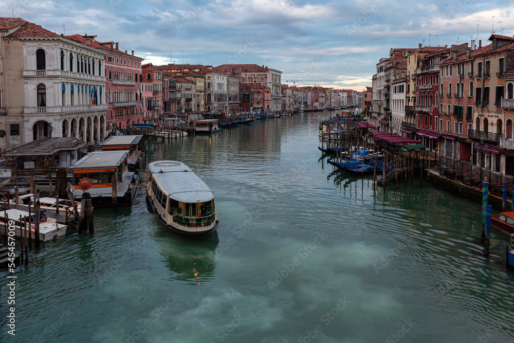 The ferry sails along the Grand Canal of Venice at the dawn of a summer day