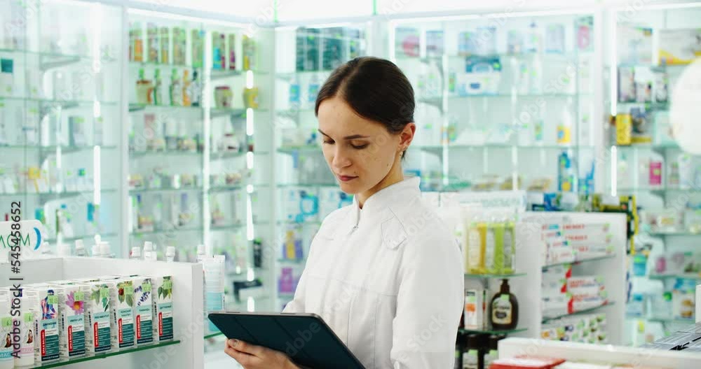 friendly pharmacist does an inventory at a provided and modern pharmacy. Portrait of a female doctor working in a pharmacy with a digital tablet. High quality 4k footage friendly pharmacist does an inventory at a provided and modern pharmacy. Portrait of a female doctor working in a pharmacy with a digital tablet. High quality 4k footage