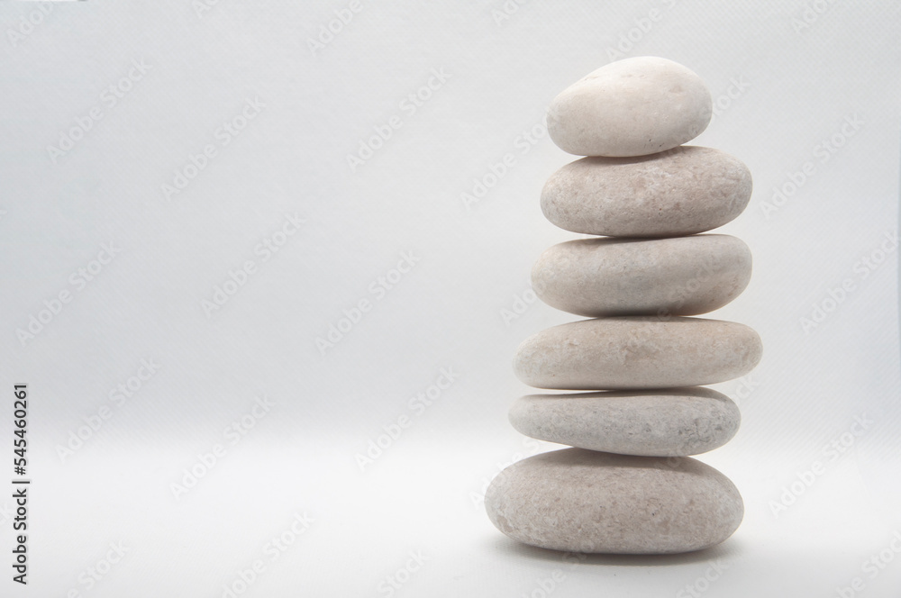 Zen stones stacking on white background with customizable space for text or ideas. Copy space. Zen stones stacking on white background with customizable space for text or ideas. Copy space.