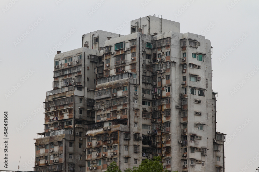 Exterior of an old skyscraper against a cloudy sky in Kowloon, Hong Kong