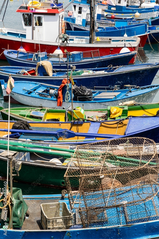 Vertical shot of colorful fishing boats side by side hanging at the harbor Vertical shot of colorful fishing boats side by side hanging at the harbor