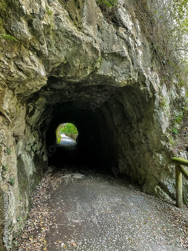 Trail through a tunnel in a rocky mountain on a sunny day in Proaza Spain photo