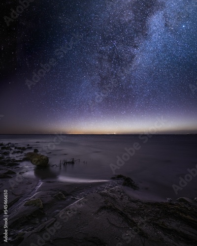 Beautiful scenery of a beach with a sky and shiny stars at night