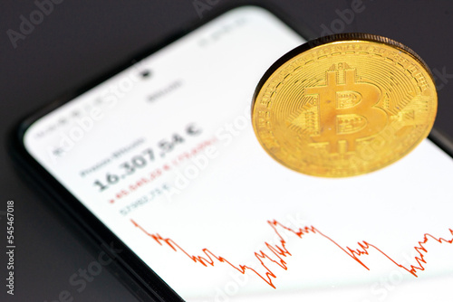 Bitcoin -  app per smartphone con prezzo bitcoin con grafico e moneta d'oro photo